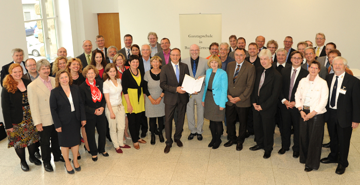 Eine Gruppe von Menschen stehen im Halbkreis nebeneinander. 